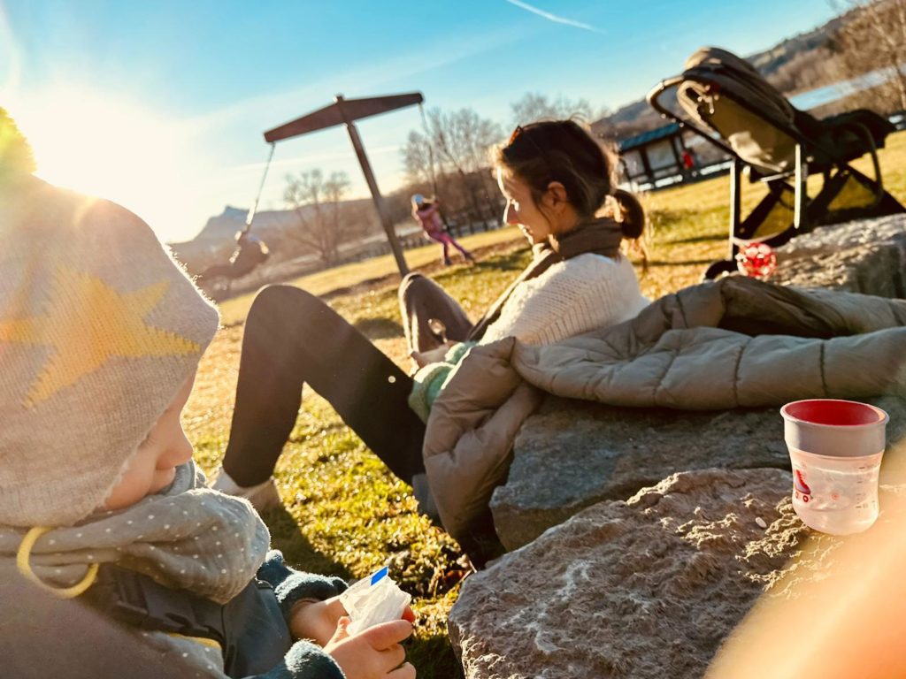 Unsere Bloggerin Leo sitzt in der Herbstsonne, im Vordergrund spielt ihr Wunschkind