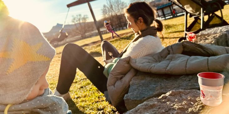 Unsere Bloggerin Leo mit Ihrem Wunschkind sitzt in der Herbstsonne im Vordergrund speilt ihr Wunschkind das sie nach jahren des unerfüllten Kinderwunsches endlich bekommen durfte!