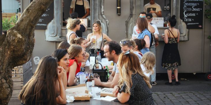 Menschen bei einer Afterwork Party irgendwo im warmen, beim Feierabend Bier und Cocktail
