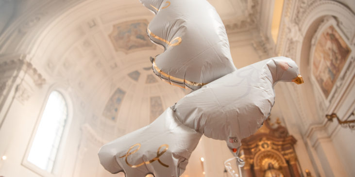 Taubenballon schwebt im Kirchenschiff.