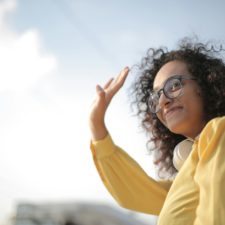 Abschied mit Vorfreude, Dankbarkeit und einem Hauch Wehmut Frau Im Gelben Top Winken