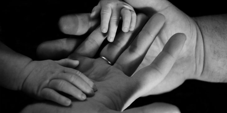 Baby-Hände halten Erwachsenen-Hände