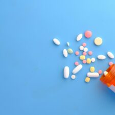 Diagnose neurodivergent Pillen und offene Pillendose auf blauem Hintergrund